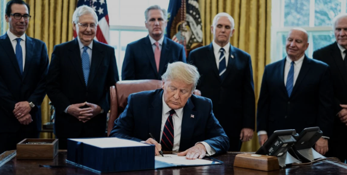 Trump signing the CARES Act stimulus package
